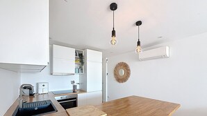 Une cuisine moderne avec un plan de travail en bois, un four encastré, un évier et une chaise noire.