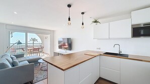 Une cuisine moderne avec des armoires blanches, un plan de travail en bois et un four encastré.