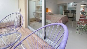 Une chambre d’hôtel moderne avec un balcon, un lit, un bureau et une chaise.