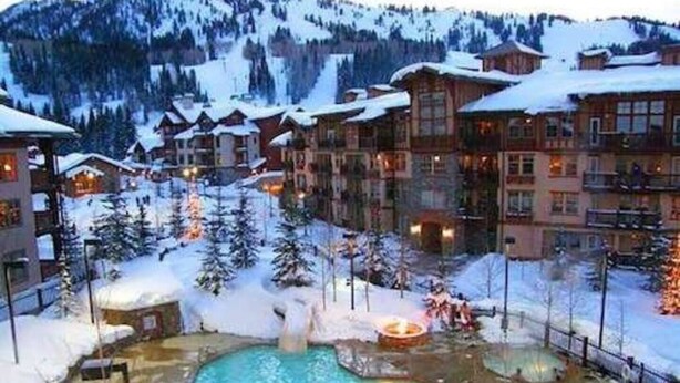 Ein Resort mit mehreren Gebäuden, einem zentralen Poolbereich und verschneiter Umgebung.