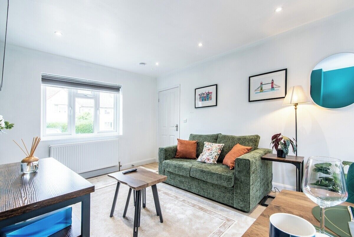 A living room with a green sofa, a coffee table, a lamp, and a framed picture on the wall.