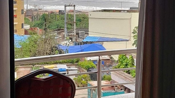 Un balcón con vista al mar y edificios.