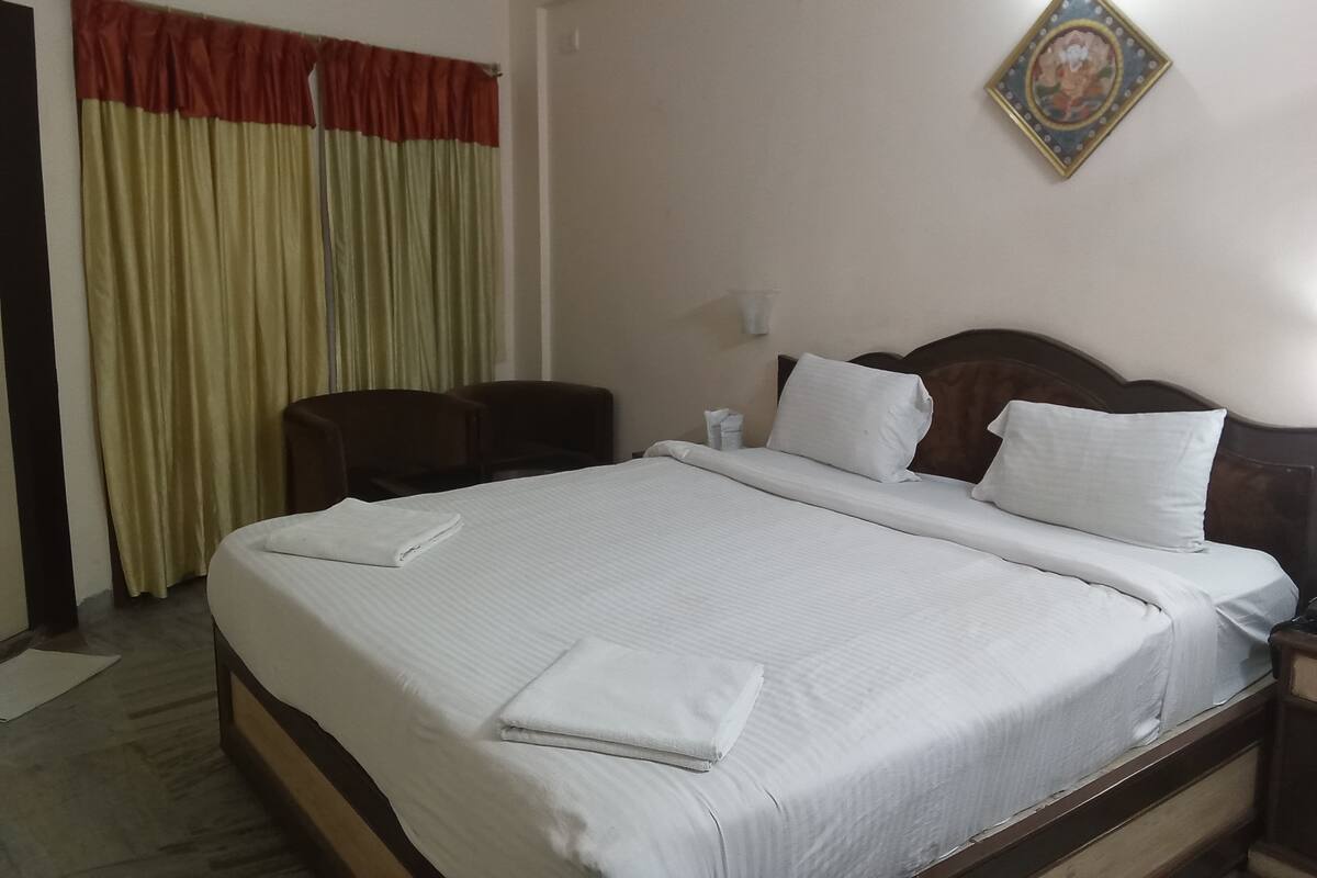 A neatly made bed with white linens, a wooden headboard, and two bedside tables with lamps.