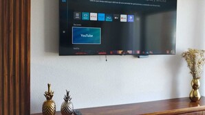 Un televisor de pantalla plana montado en una pared con un mueble bajo.