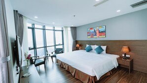 A modern hotel room with a large bed, a desk, a chair, and a TV. - Legend Westlake Hotel (Hanoi)