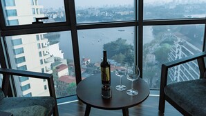 A high-rise room with a large window overlooking a cityscape and river. - Legend Westlake Hotel (Hanoi)