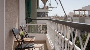 A balcony with two chairs, a table, and a potted plant. - Athenian Hillside Apartment (Athens)