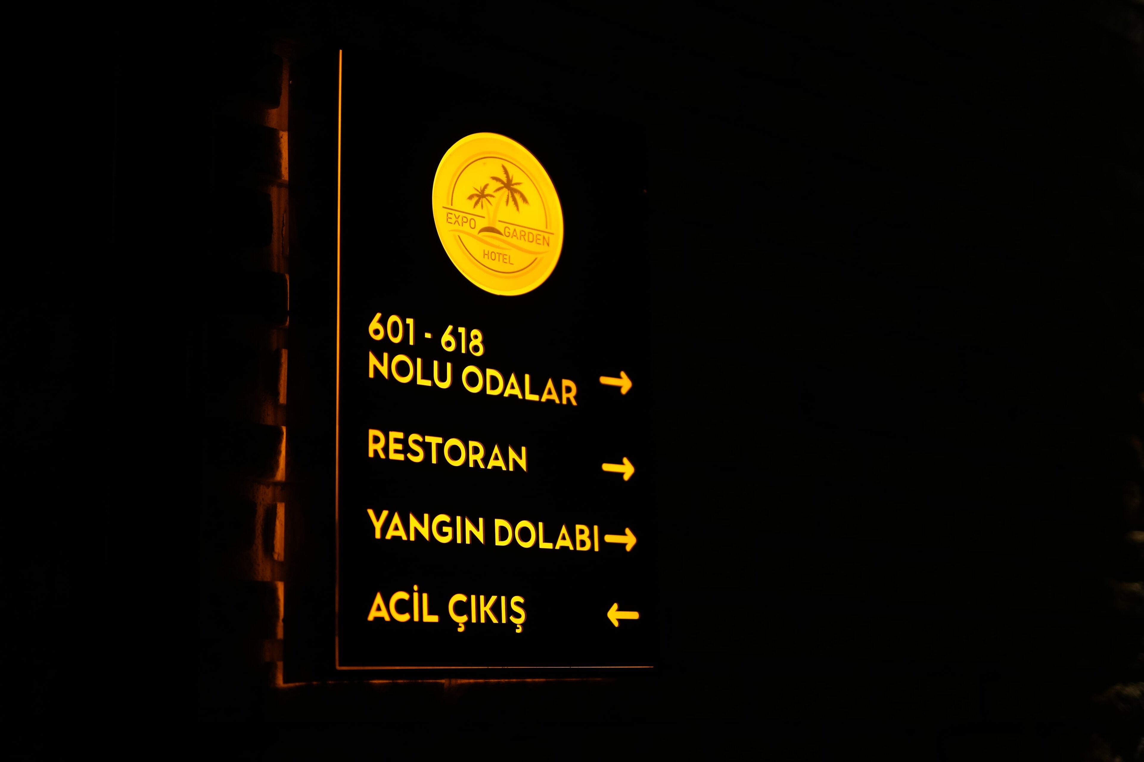 A sign with directions to various hotel areas, including a restaurant and a pool.