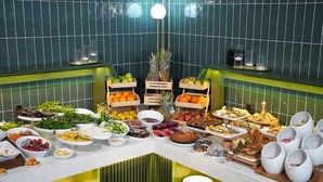 Un bufé con diversas opciones de comida y bebidas, incluyendo frutas, verduras y postres.