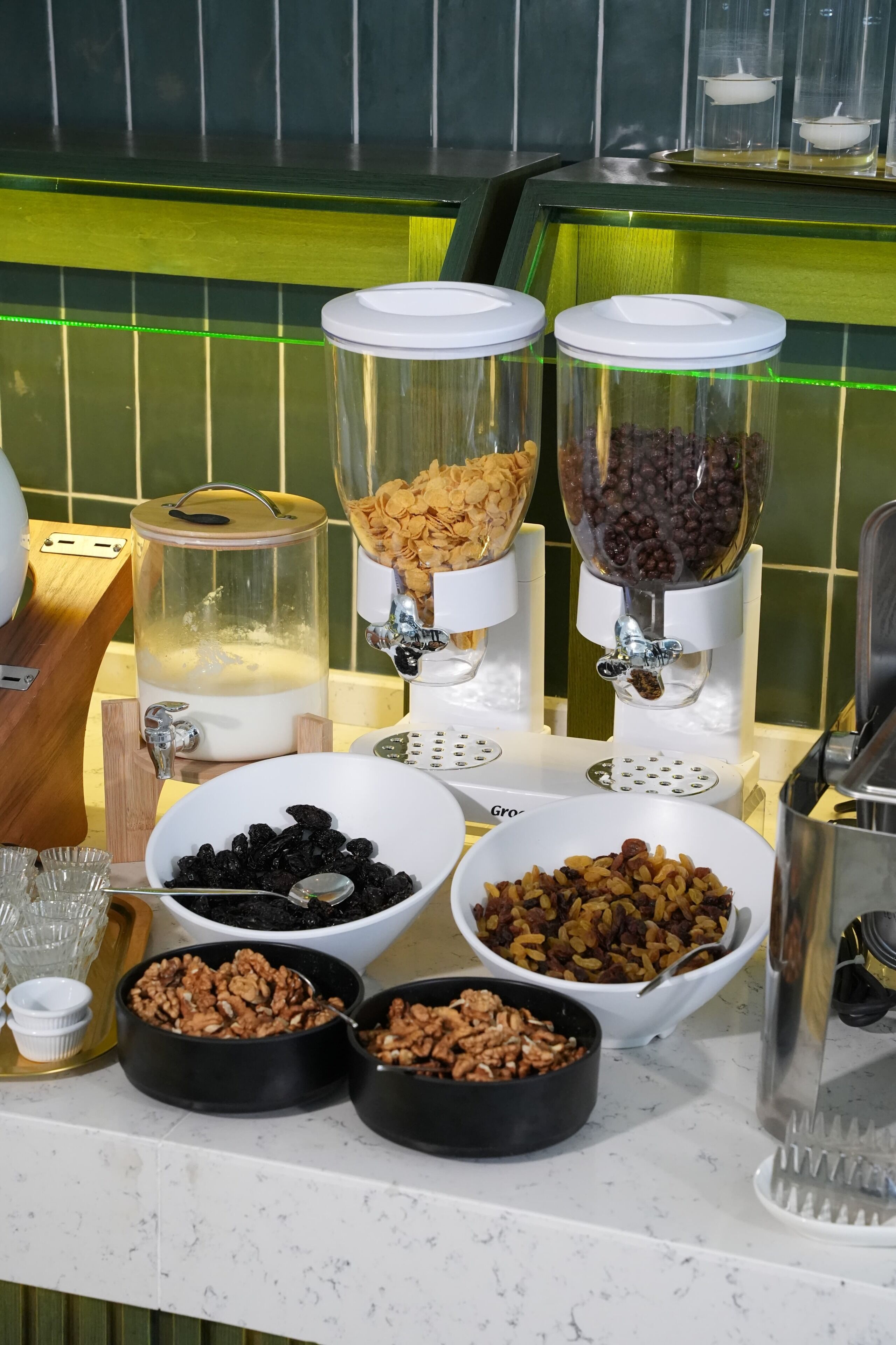 Una encimera de cocina con varios dosificadores de alimentos y cuencos de nueces y frutas secas.