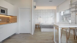 Een moderne, compacte slaapkamer met een bed, nachtkastjes en een raam.