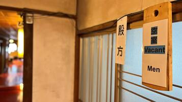 A hotel corridor with signs indicating a vacant men's room.