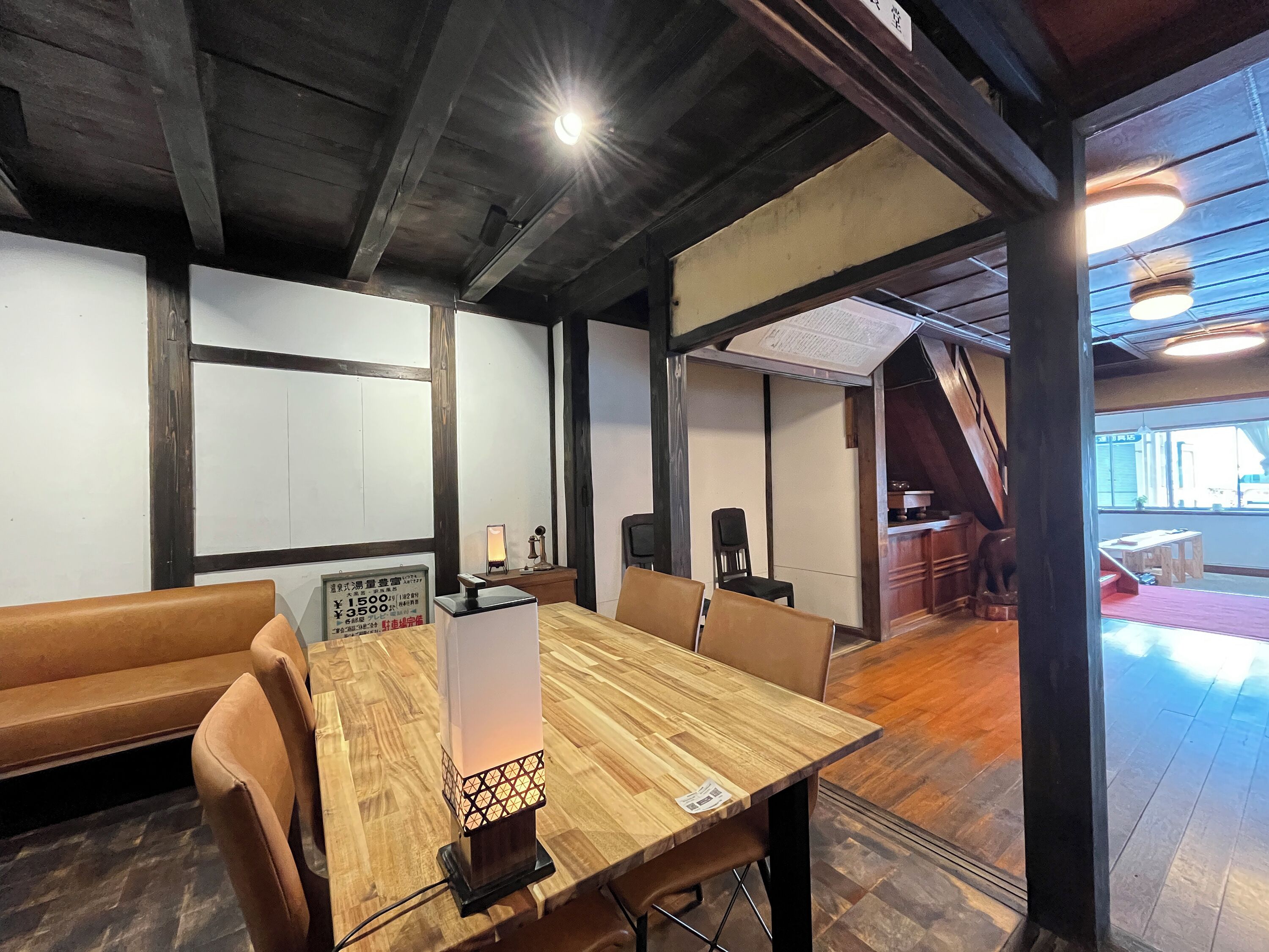 Un salón de conferencias con una mesa de madera, sillas de cuero, una pizarra y una lámpara.