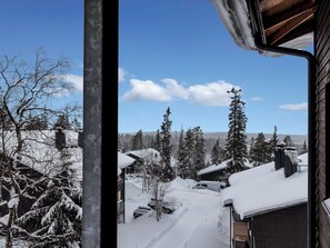 A snowy landscape with a cabin and trees.