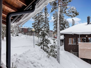 Un paisaje nevado con un edificio de madera y árboles cubiertos de nieve.