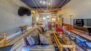 Ein gemütliches Wohnzimmer mit einer Couch, Holzbanken und einem Essbereich.