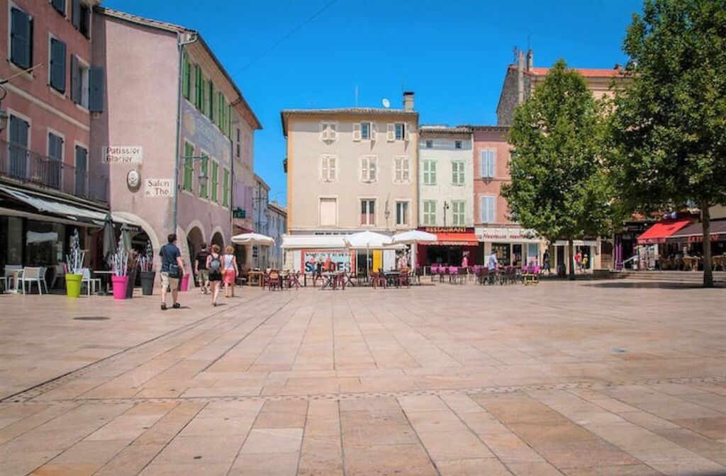 Ein weitläufiger öffentlicher Platz mit Cafés und Geschäften.