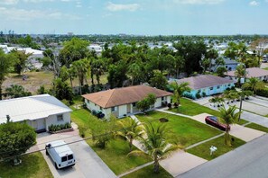 A residential area with houses, a white van, and a red car parked on the street. - 3 miles to Fort Myers Beach with king bed (Fort Myers Beach)