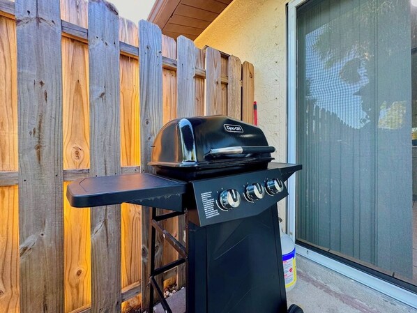 A portable gas grill with four burners, a side shelf, and a control panel. - Near Fort Myers Beach • King Bed • Grill (Fort Myers Beach)