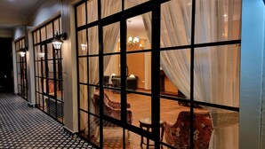 A corridor with patterned flooring leading to a room with a patterned wall, a sofa, and a table. - Marten's Wilderness Retreat (Lansdowne)