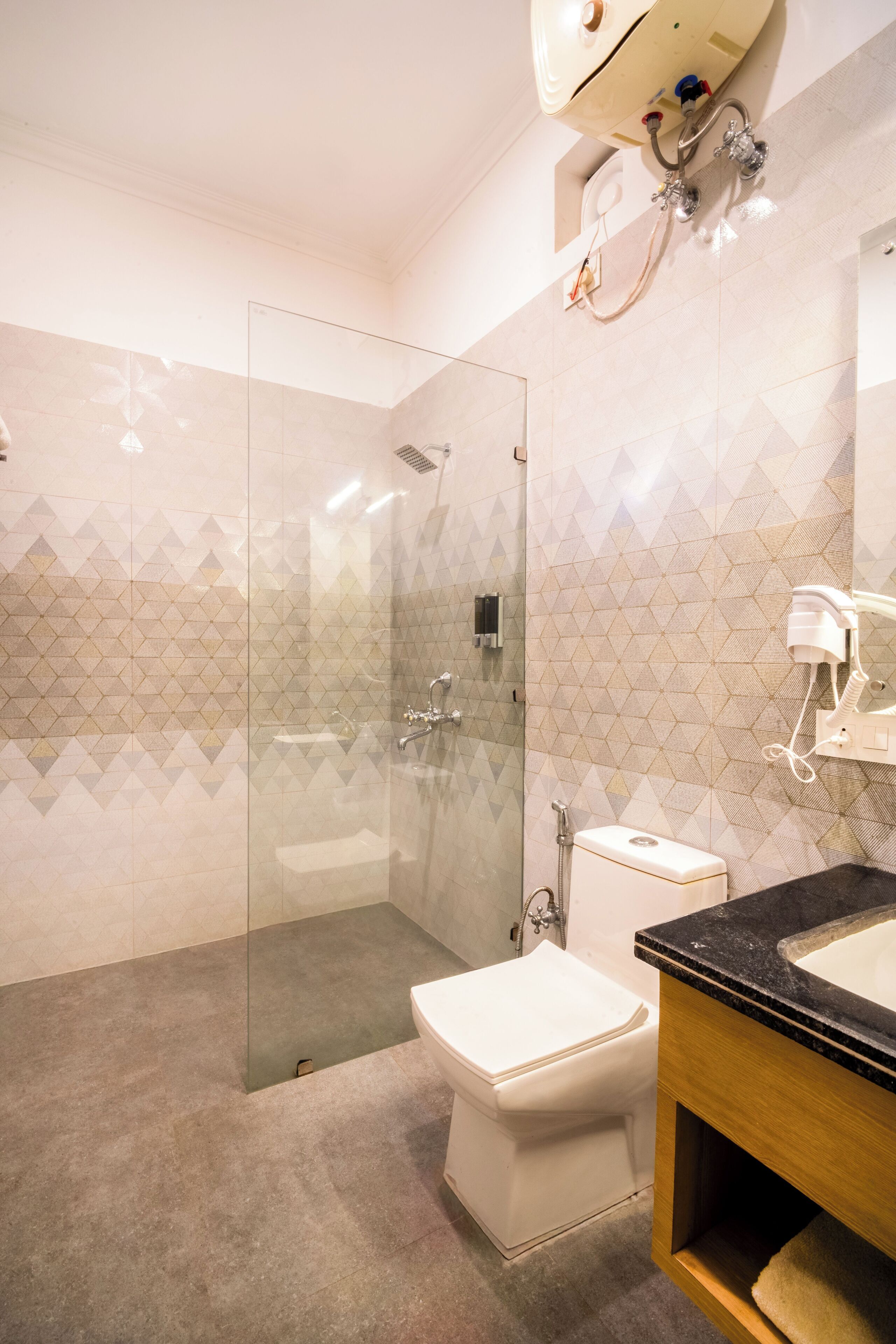 A modern bathroom with a glass-enclosed shower, a white toilet, and a black countertop sink.