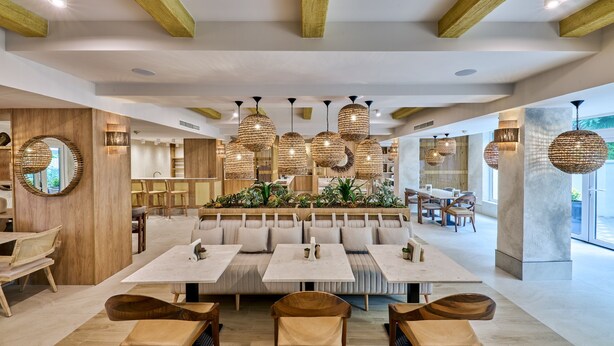 A modern restaurant with wooden beams, round hanging lights, and a central seating area with tables and benches. - Serenity Hotel (Timisoara)