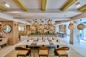 A modern restaurant with wooden beams, round hanging lights, and a central seating area with tables and benches. - Serenity Hotel (Timisoara)