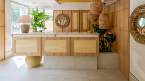A modern kitchen with wooden cabinetry, woven pendant lights, and a central island. - Serenity Hotel (Timisoara)