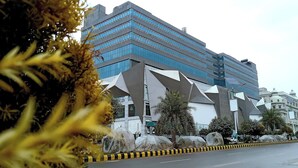 A modern building with a unique geometric facade, large windows, and a prominent entrance. - Luxury Apartment in Islamabad (Islamabad)