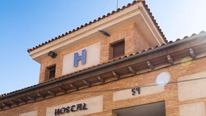 Un edificio con un cartel que dice "HOSPITAL" y la letra "H" en el techo.