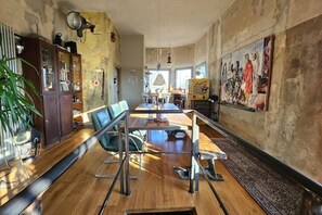 A spacious dining area with a long wooden table, modern chairs, and a central glass partition. - Historic Linn signal box (Krefeld)