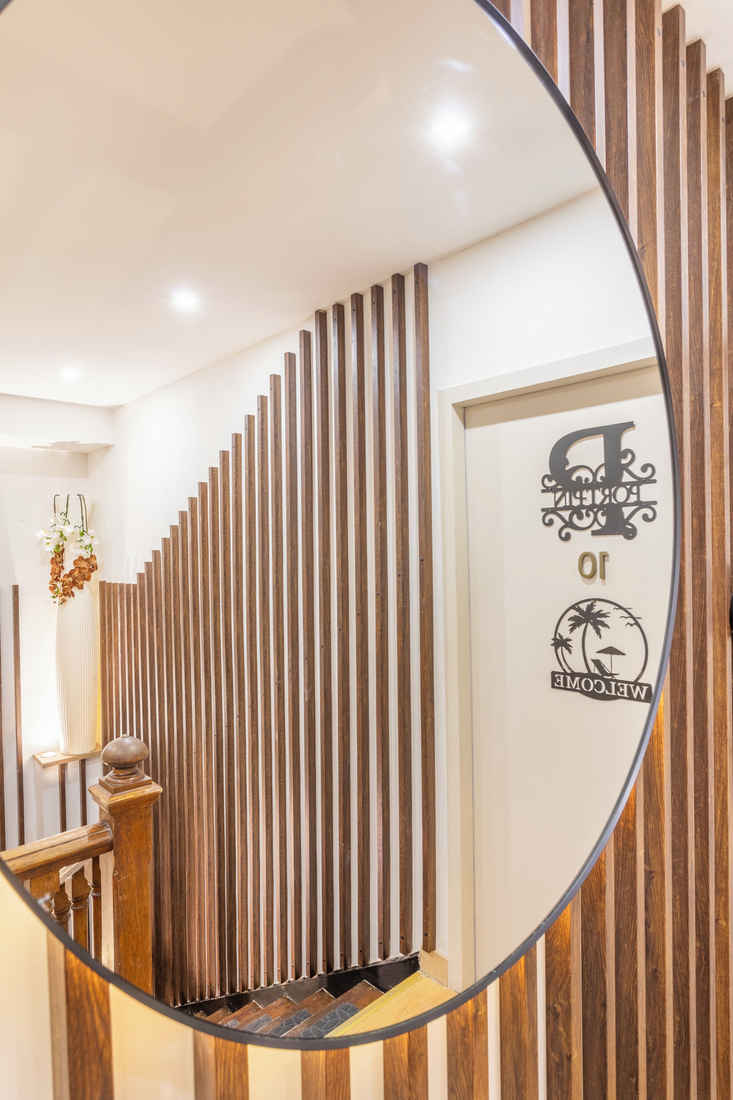 A modern interior with a wooden slat wall, a reception desk, and a welcome sign.