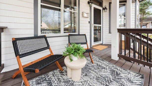 A porch with two wooden benches, a potted plant, and a patterned rug. - Espresso Martini (Atlanta)