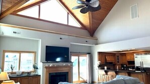 A spacious living room with a fireplace, a television, and a large window.