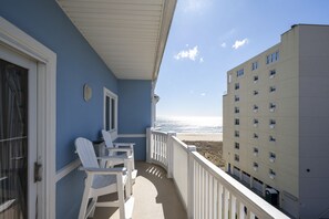 A balcony with white chairs and a view of the beach. - Luxury Awaits Your Family in This Stunning Sideview Oceanfront Property (Ocean City)
