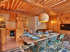 Un interior rústico de madera con comedor, cocina y zona de estar.