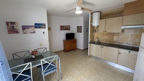 Eine kleine Küche mit Holzausstattung, integriertem Herd und Deckenventilator.