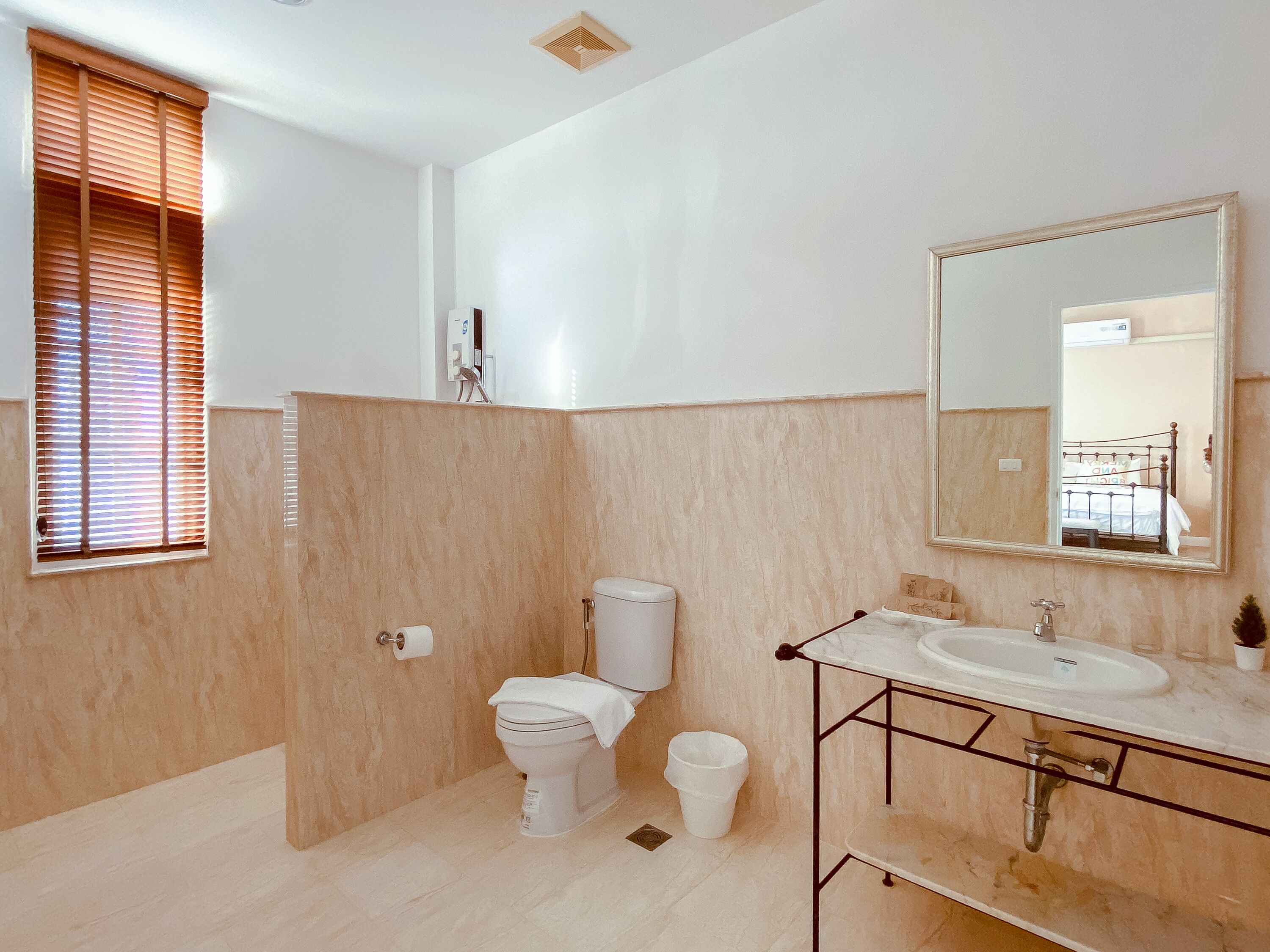 Une salle de bain équipée de toilettes, d’un bidet, d’un lavabo et d’un miroir.