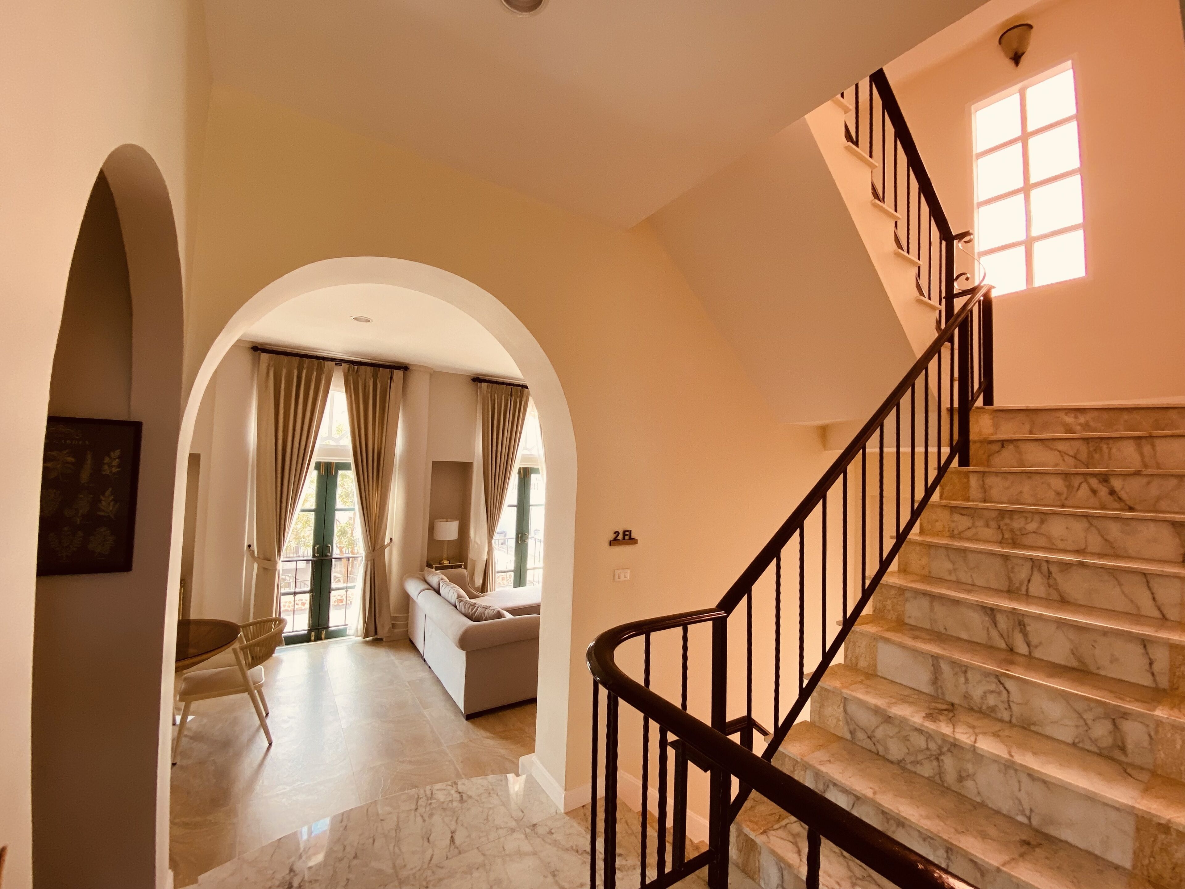 Ein geräumiger Korridor mit einer Marmortreppe, die zu einem Balkon führt.