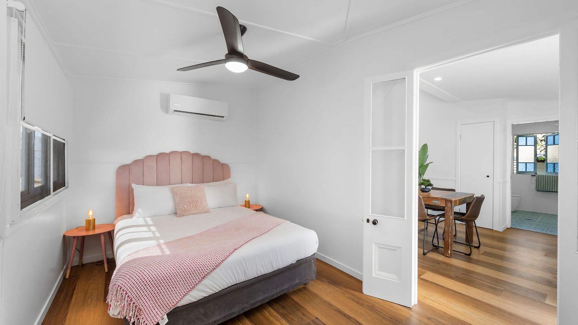 Una camera da letto con un letto, comodini, una ventola a soffitto e un condizionatore d'aria.