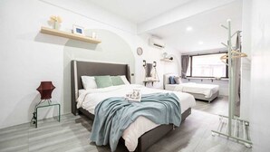 A modern bedroom with a large bed, a bedside table, a chair, a window, and a wardrobe. - Roombix CityHouse -CozyHouse Chatuchak For 12 ppl - RB2 (Krung Thep Maha Nakhon)