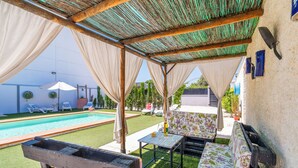 Un espacio de estar al aire libre cubierto con una piscina al fondo.
