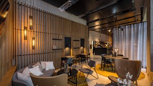 Un interior modern amb un sof à, cadires, una taula de centre i una zona de menjador.