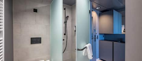 A modern bathroom with a glass shower enclosure, a toilet, and a sink.