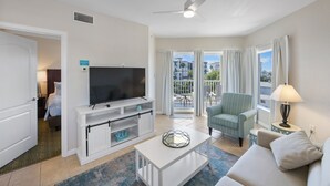 Hotelkamer met televisie, zithoek en balkon met uitzicht.