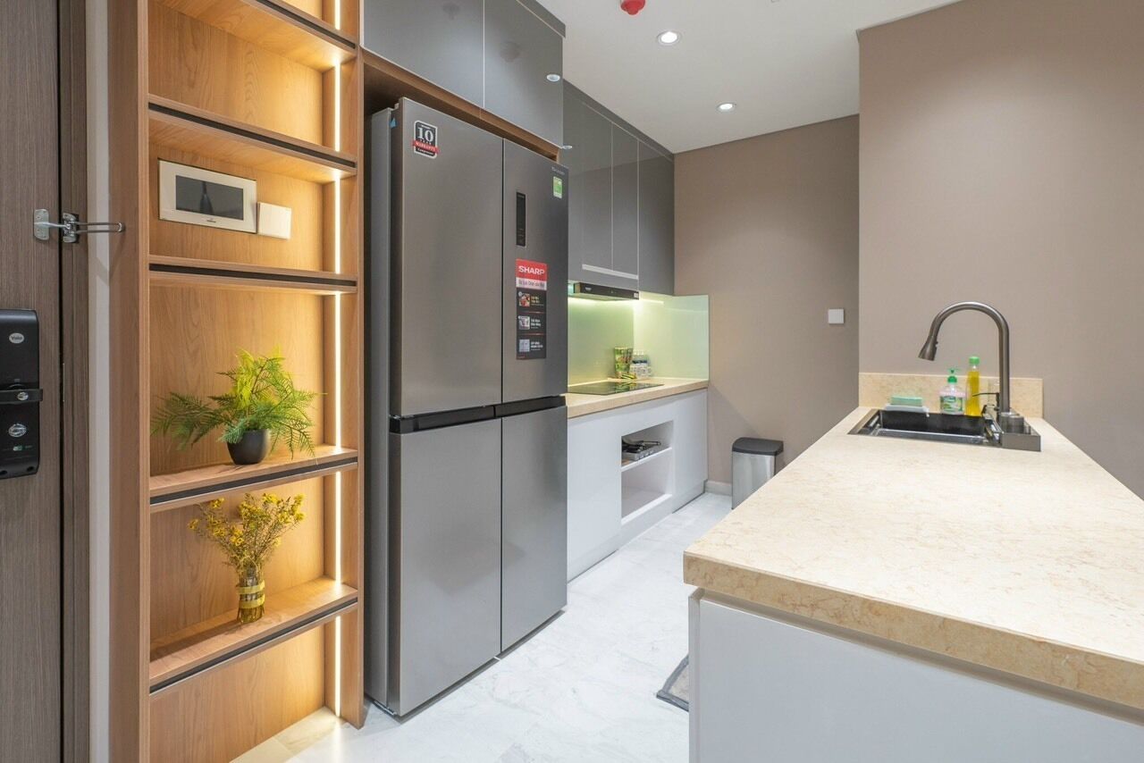 Une cuisine moderne équipée d’un réfrigérateur encastré, d’un four à micro-ondes et d’un évier.