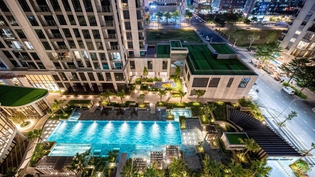 A rooftop pool area with a swimming pool, lounge chairs, and greenery. - Happy Light Apartment in the Cardinal Court  (Ho Chi Minh City)