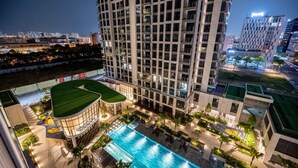 A high-rise hotel with a rooftop pool and surrounding greenery. - Happy Light Apartment in the Cardinal Court  (Ho Chi Minh City)