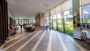 A spacious indoor area with large windows, modern furniture, and a clean, contemporary design. - Happy Light Apartment in the Cardinal Court  (Ho Chi Minh City)