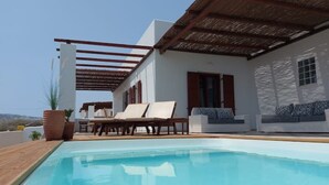 Ein Poolbereich mit Pool, Liegestühlen und einer Pergola.